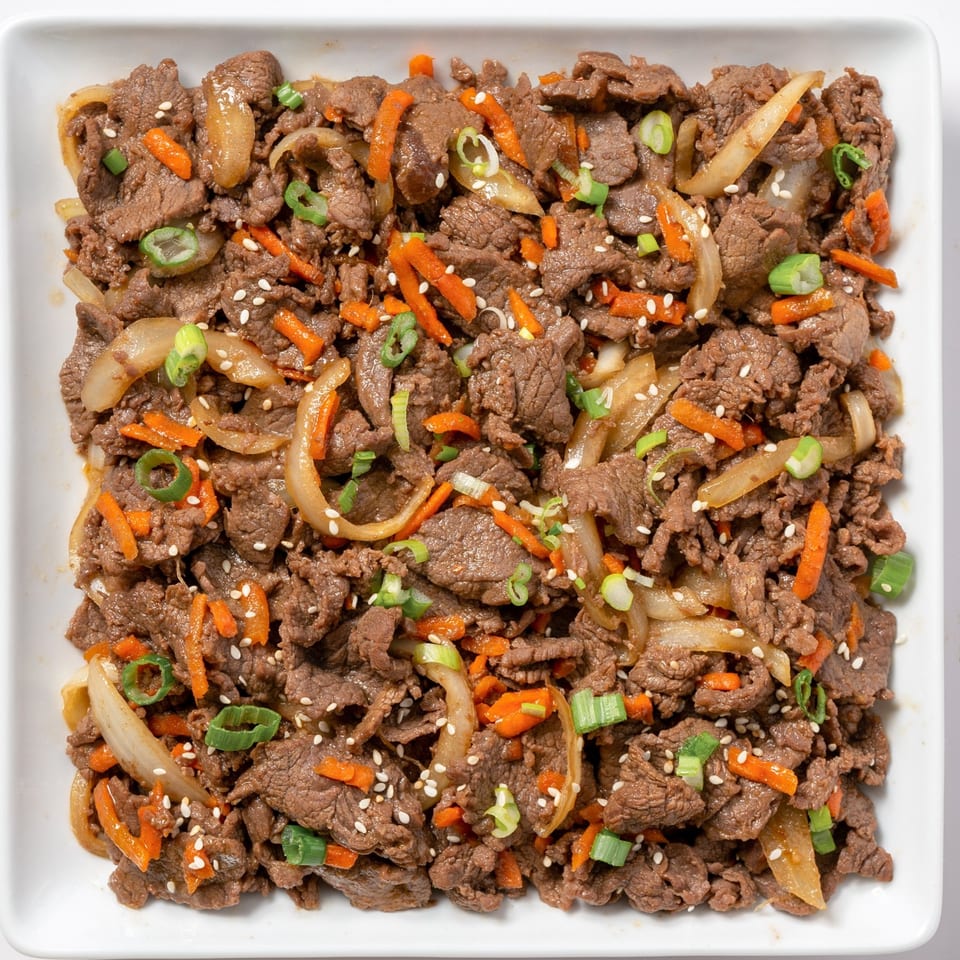 Zing's bulgogi features thinly sliced beef, carrots, onions, and scallions, topped with sesame seeds.