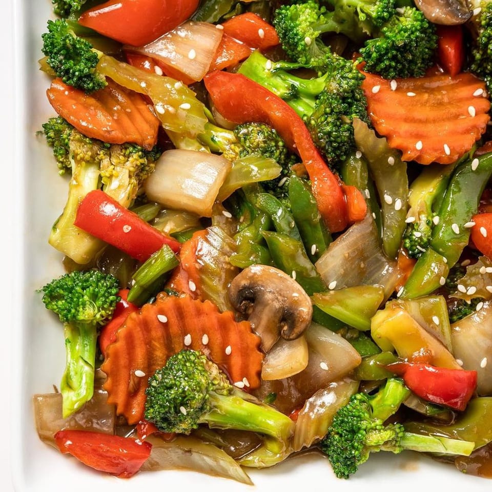 Close-up of Zing's colorful stir-fried vegetables with broccoli, carrots, peppers, and sesame seeds.